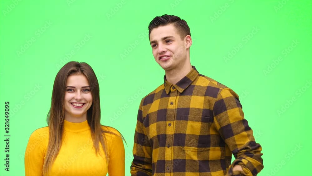 Tender loving couple is smiling sincerely on a green background. Close up. Copy space. 4K. Tender loving couple is smiling sincerely on a green background. Close up. Copy space. 4K.