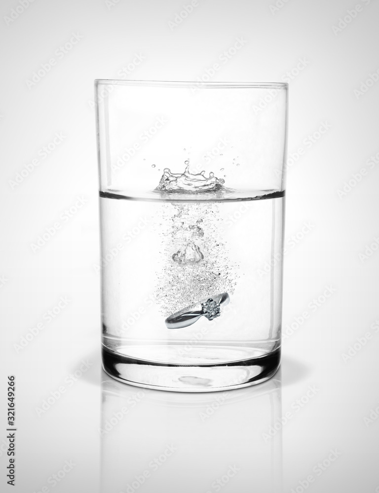 Glass of water with wedding ring. Glass of water with wedding ring.