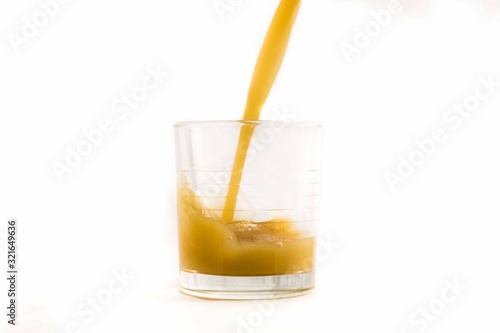 orange juice splash in a glass on a white backgound healty beverage