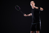 Badminton player in sportswear with racket and shuttlecock on black background. Individual sports. Sports recreation.