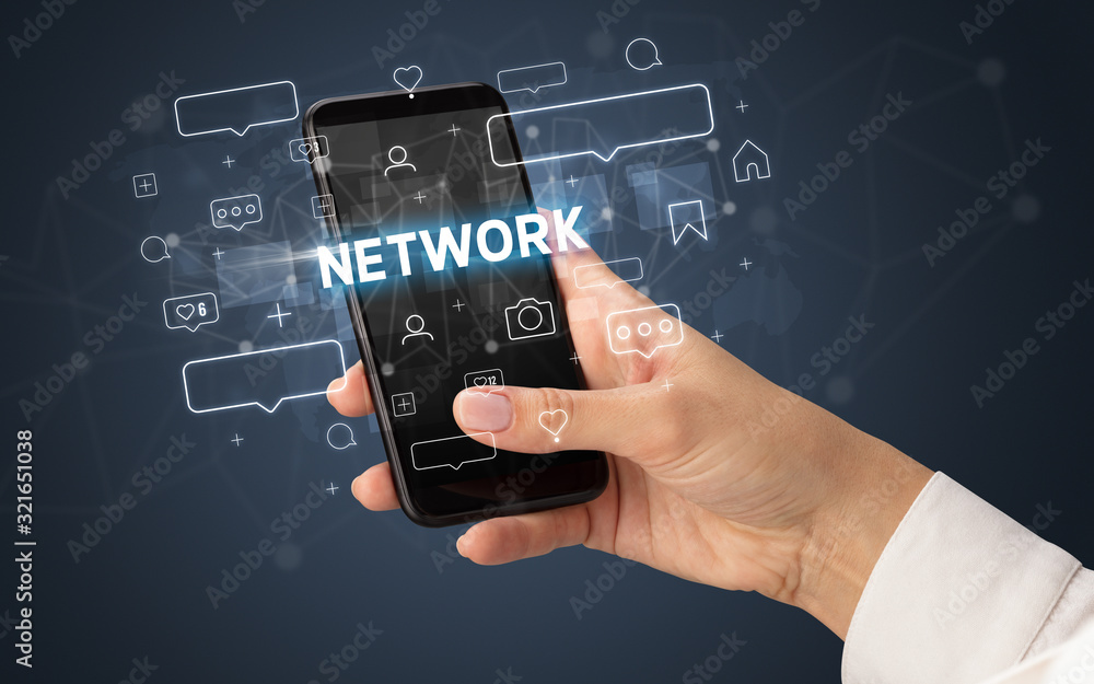 Female hand typing on smartphone with NETWORK inscription, social media concept Female hand typing on smartphone with NETWORK inscription, social media concept