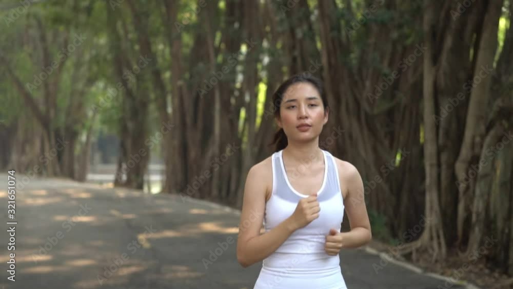 Slow motion, Follow young Asian girl running in a park during summer day Slow motion, Follow young Asian girl running in a park during summer day