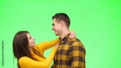 Tender loving couple meet on a green background. Boy is waiting for his girlfriend. Close up. Copy space. 4K.