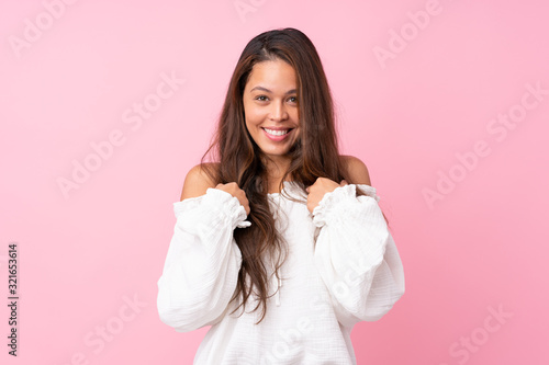 Young Brazilian girl over isolated pink background with surprise facial expression © luismolinero