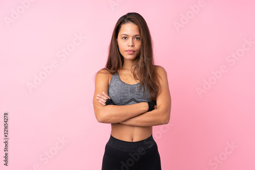 Young sport Brazilian girl over isolated pink background with arms crossed