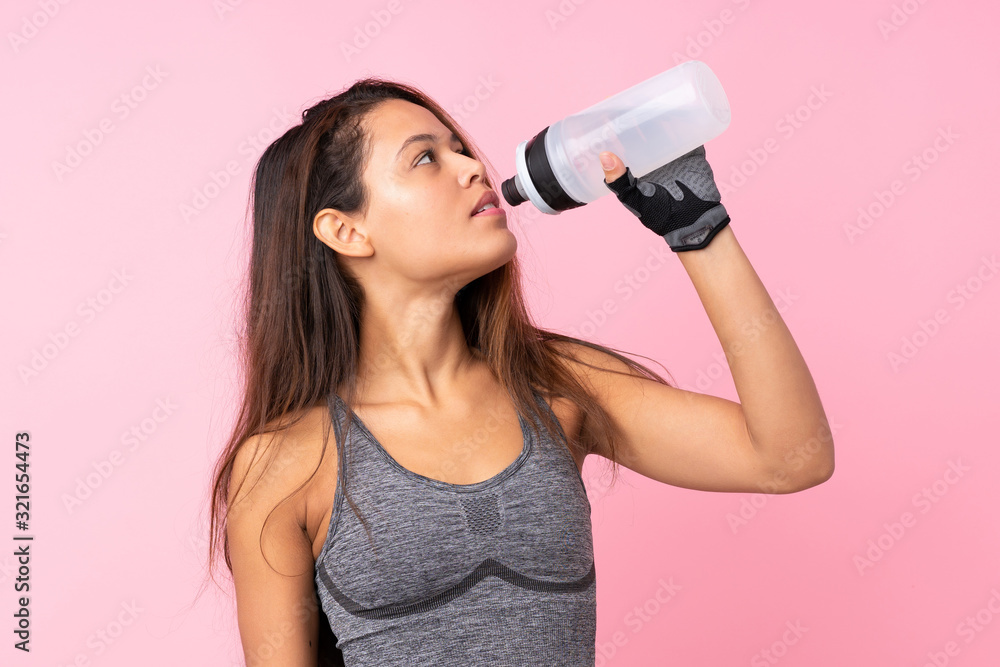 Young sport Brazilian girl over isolated pink background with sports water bottle Young sport Brazilian girl over isolated pink background with sports water bottle