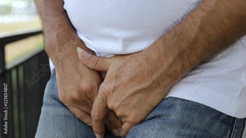 Close up of a man with hands holding his crotch, Urinary Tract Infection concept Painful Bladder Syndrome and interstitial cystitis photo