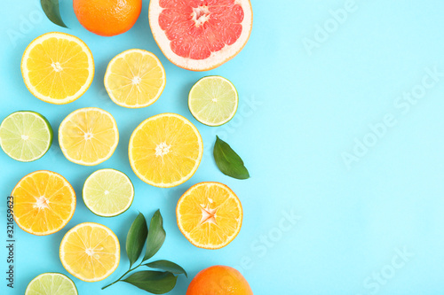 Different citrus and juicy slices on a colored background top view. Place to insert text.