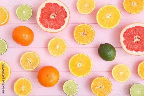 Different citrus and juicy slices on a colored background top view. Place to insert text.