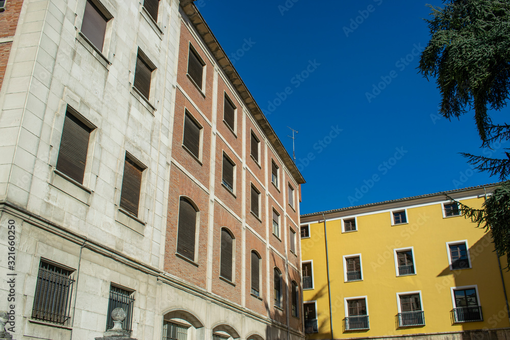 Edificios antiguos de piedra y fachada amarilla.