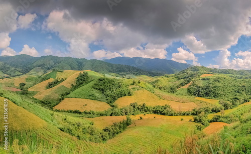 view panorama of agriculture plantations on side hill with green nature and cloudy sky background, Phop Phra District, Tak Province, western of Thailand.