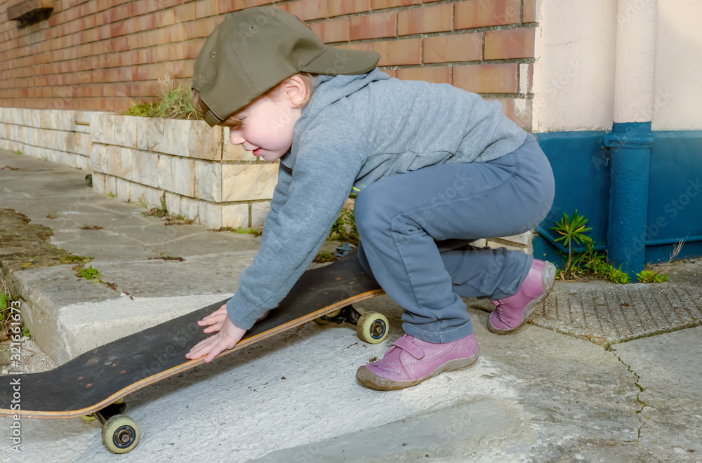 cute little girl playing with sin skate board on the street cute little girl playing with sin skate board on the street