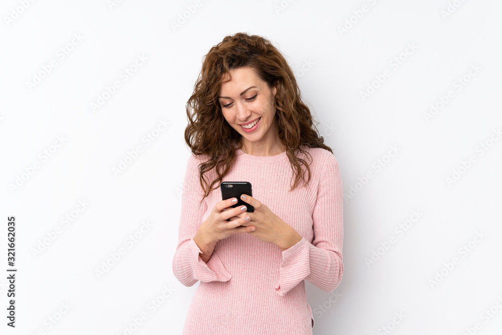 Young pretty woman over isolated background sending a message or email with the mobile Young pretty woman over isolated background sending a message or email with the mobile