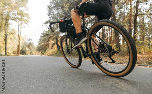 Closeup photo of a man riding an extreme bicycle on a forest road. Cyclist in motion rides a forest on a bicycle. Closeup photo in motion