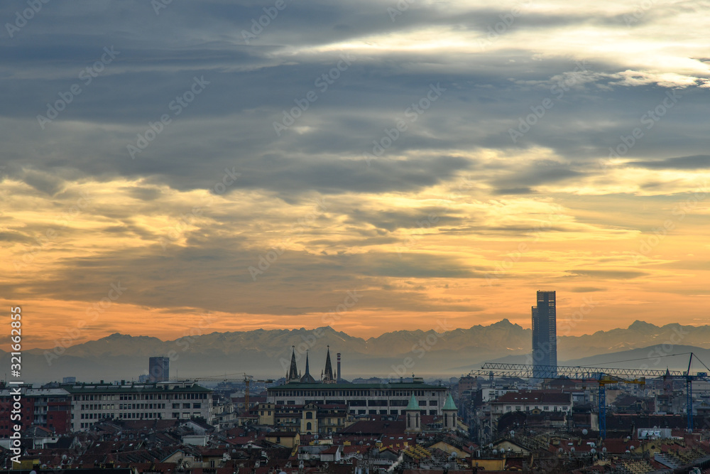 Rooftop view of the city centre of Turin with the Alps mountain range in the background at sunset, Piedmont, Italy