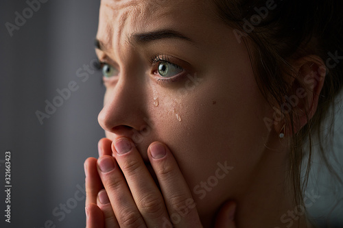 Fotografia Sad desperate crying female with folded hands and tears eyes during trouble, lif