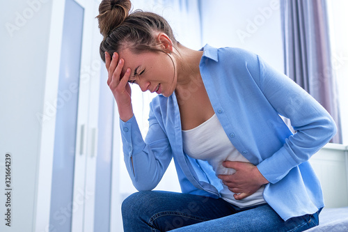 Sickness woman suffering from pms and menstruation pain. Having stomach ache, abdominal pain and headache because of critical days. Inflammation and infection bladder, cystitis. Health problems