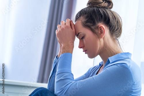 Sad lonely depressed hopeless woman teenager with folded hands lost in thoughts during thinking about life and worried about emotional problems