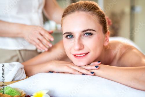 Beautiful young attractive Caucasian woman having body massage by Thai Masseur in spa salon. Beauty treatment and body care lifestyle concept