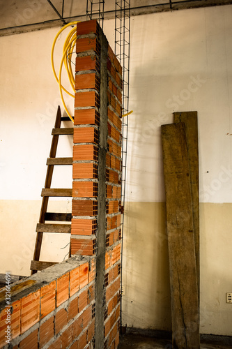 Parede de alvenaria em construção. Tijolo baiano, coluna de concreto armado