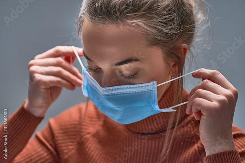 Healthy woman putting on medical protective mask to health protection and prevention during flu virus outbreak, epidemic and infectious diseases photo