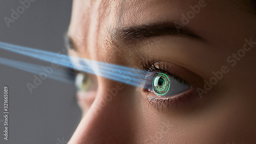 Female eye with smart contact lens with digital and biometric implants to scan the ocular retina close up. Future concept and high tech technology for scanning face id
