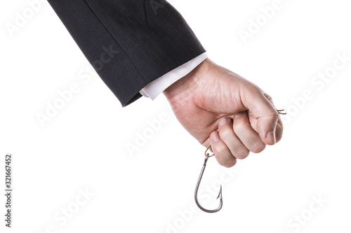 A man in a suit holds a fishing hook tightly in his hand isolated on a white background. Concept on a hook