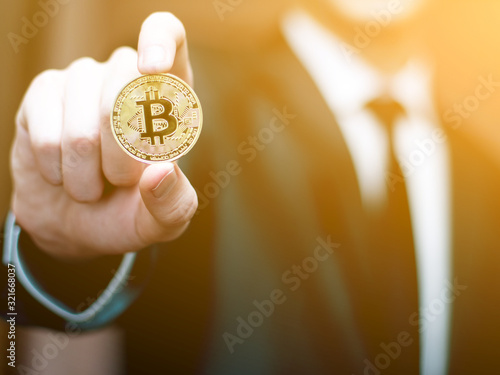 Male hand hold bitcoin. Businessman in suit show bit coin. Stock photo with flare. Cryptography concept