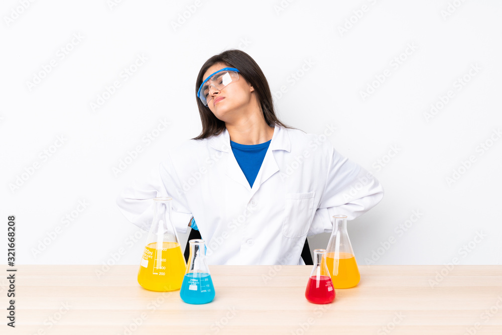Young scientific woman in a table suffering from backache for having made an effort Young scientific woman in a table suffering from backache for having made an effort