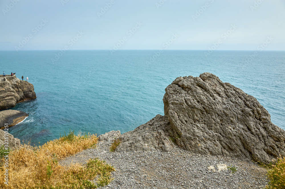 Beautiful bay, fishermen on the rocks. View from a mountain trail off the Black Sea coast, Novyi Svet village, Crimea