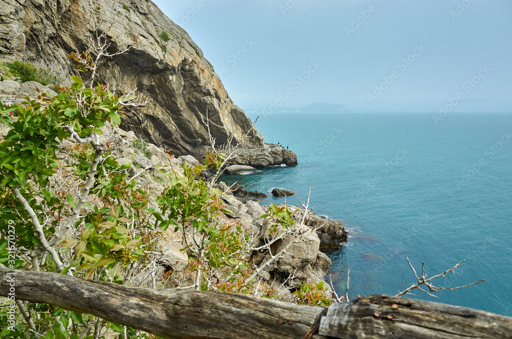 Beautiful bay, fishermen on the rocks. View from a mountain trail off the Black Sea coast, Novyi Svet village, Crimea