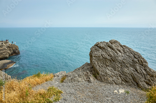 Obraz na płótnie Beautiful bay, fishermen on the rocks. View from a mountain trail off the Black Sea coast, Novyi Svet village, Crimea w salonie