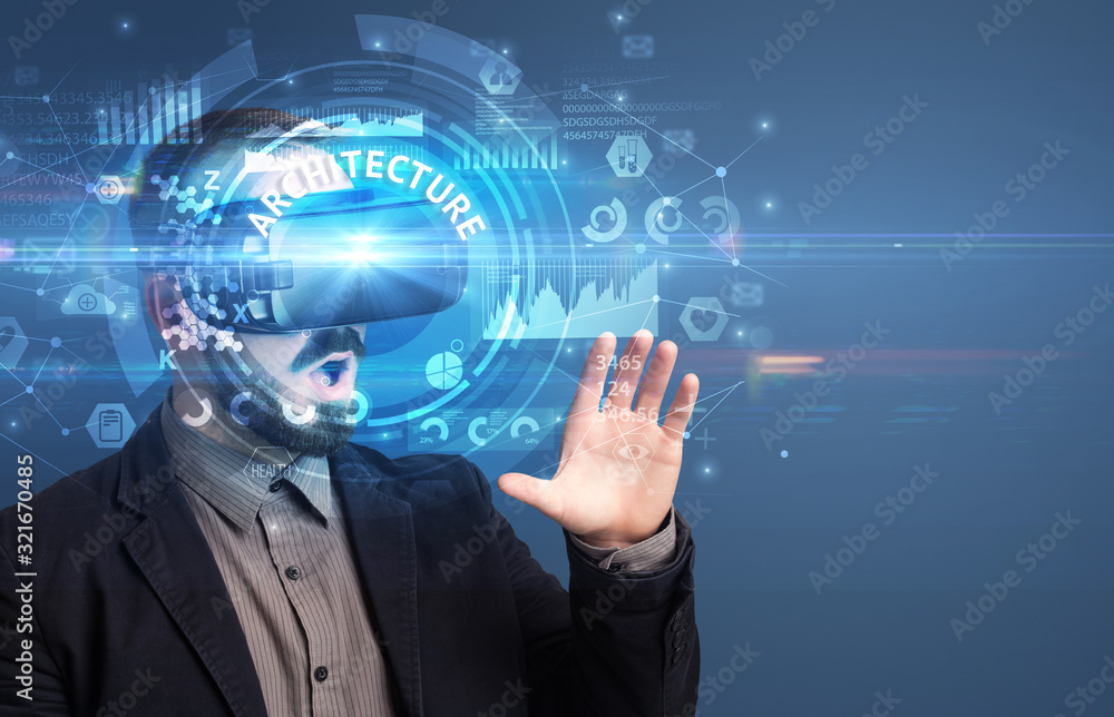 Businessman looking through Virtual Reality glasses with ARCHITECTURE inscription, innovative technology concept Businessman looking through Virtual Reality glasses with ARCHITECTURE inscription, innovative technology concept