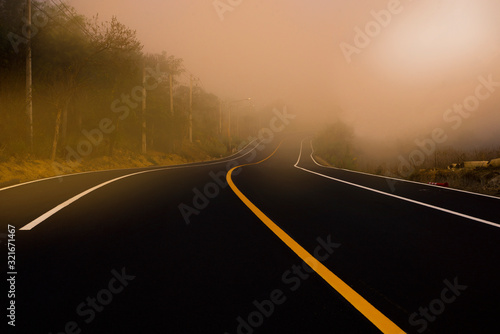 The sun shines down on the roads in the tropical forests of Asia. The road is full of haze in the morning time. © wanchai