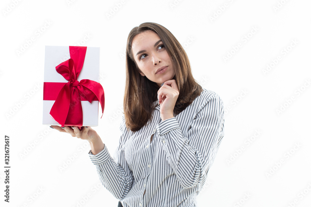 Portrait of a surprised girl who received a gift in a white box with a red ribbon Portrait of a surprised girl who received a gift in a white box with a red ribbon