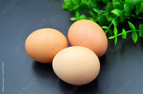 Three eggs on a black indoor background
