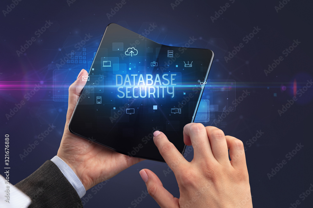 Businessman holding a foldable smartphone with DATABASE SECURITY inscription, cyber security concept Businessman holding a foldable smartphone with DATABASE SECURITY inscription, cyber security concept