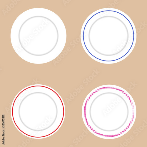 Set of white plates with various decorative elements. Light brown background.