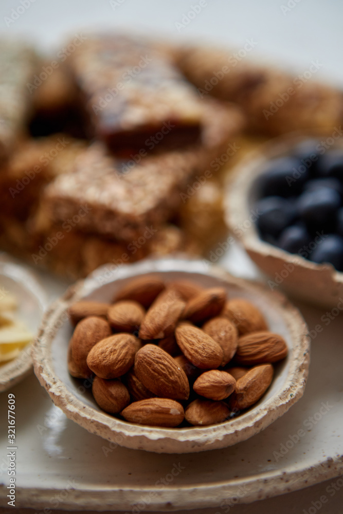 Close up of whole Almonds. With various energy nutrition bars in background Close up of whole Almonds. With various energy nutrition bars in background
