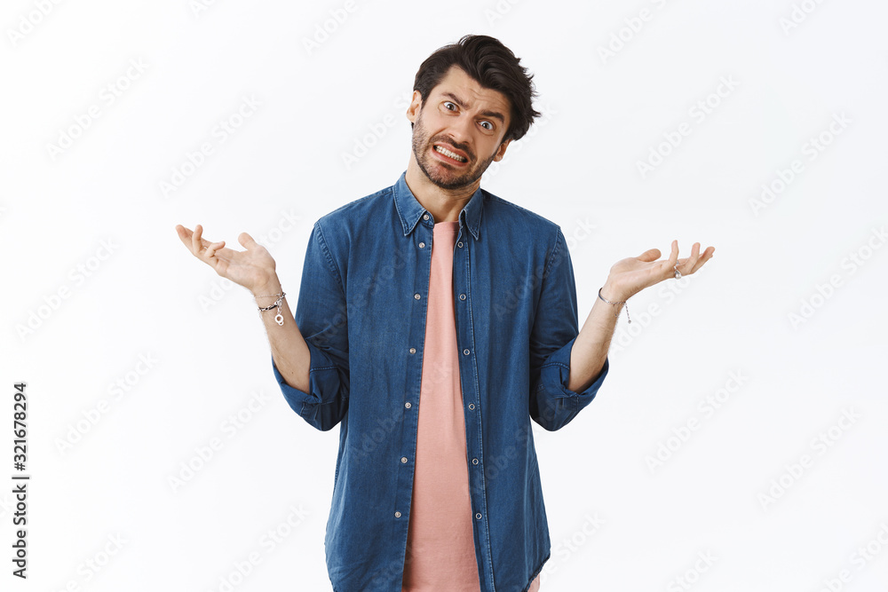 Guy avoids answers as feeling pressured and indecisive, dodging questions. Perplexed male coworker, shrugging tilt head and spread hands sideways in dont know, clueless gesture, smile awkward Guy avoids answers as feeling pressured and indecisive, dodging questions. Perplexed male coworker, shrugging tilt head and spread hands sideways in dont know, clueless gesture, smile awkward