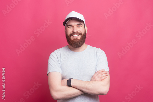 Portrait of happy man with beard with crossed arms looking confident at the camera