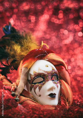 Fototapeta Naklejka Na Ścianę i Meble -  Carnival mask female theatrical face against red bokeh background. Festive party celebration
