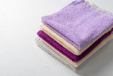 Terry towels for beauty and health. A stack of multi-colored towels lies on a white background. Lifestyle, housework.