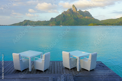 Table and chairs with a view of the Mont Otemanu and the Bora Bora lagoon in French Polynesia photo