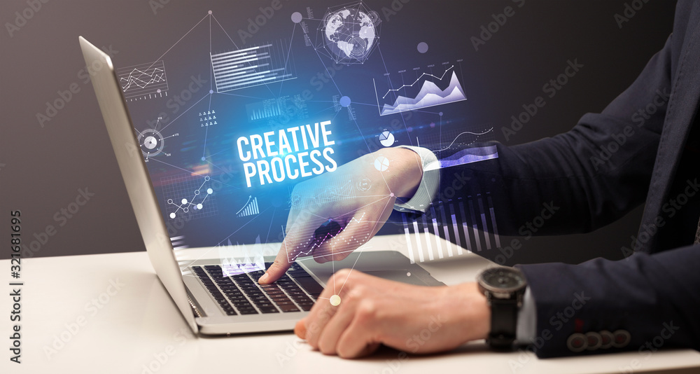 Businessman working on laptop with CREATIVE PROCESS inscription, new business concept Businessman working on laptop with CREATIVE PROCESS inscription, new business concept