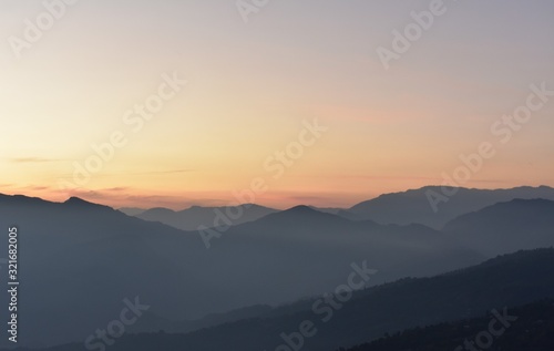 sunset in the mountains with orange sky and mist