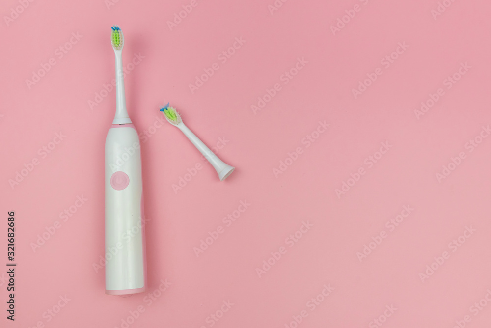 Electric toothbrush with a new head and a used one on a soft light pink background. Oral cavity home health care technology, medical concept. Copy space, top view Electric toothbrush with a new head and a used one on a soft light pink background. Oral cavity home health care technology, medical concept. Copy space, top view