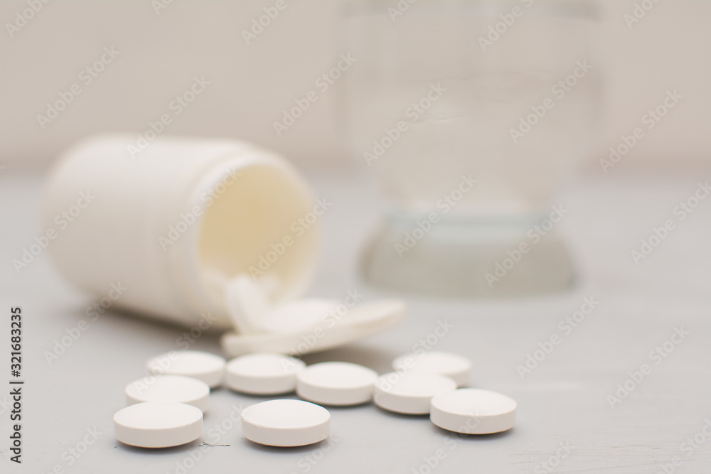 Tablets are scattered from a jar on a gray background. Tablets are scattered from a jar on a gray background.