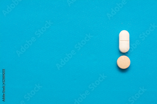 Pills in the form of an exclamation mark on a blue background.