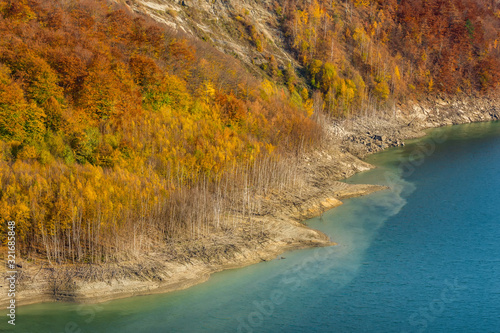 Beatiful autumn landscape with golden colored trees on the shores of Siriu lake, Siriu Dam, Buzau River Valley photo